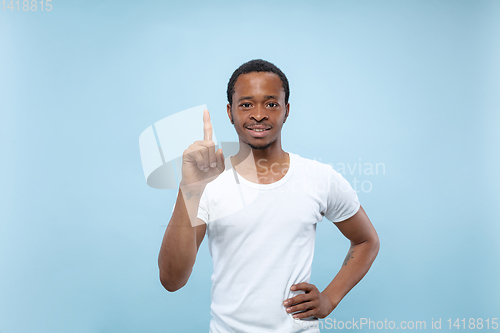 Image of Half-length close up portrait of young man on blue background.