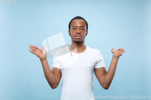 Image of Half-length close up portrait of young man on blue background.