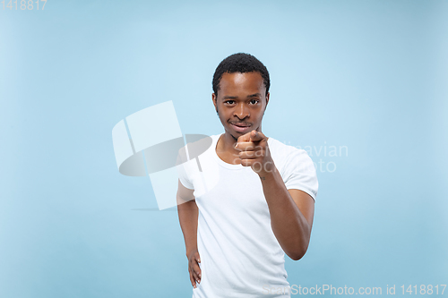 Image of Half-length close up portrait of young man on blue background.