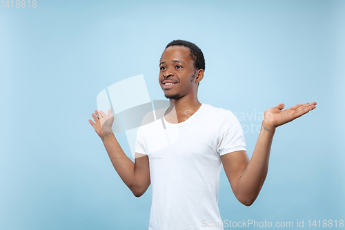 Image of Half-length close up portrait of young man on blue background.