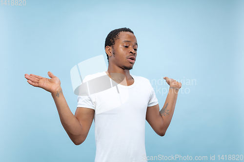 Image of Half-length close up portrait of young man on blue background.