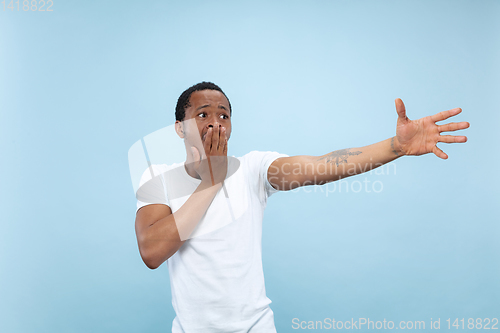 Image of Half-length close up portrait of young man on blue background.