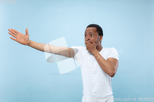 Image of Half-length close up portrait of young man on blue background.