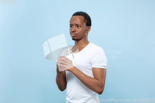 Image of Half-length close up portrait of young man on blue background.
