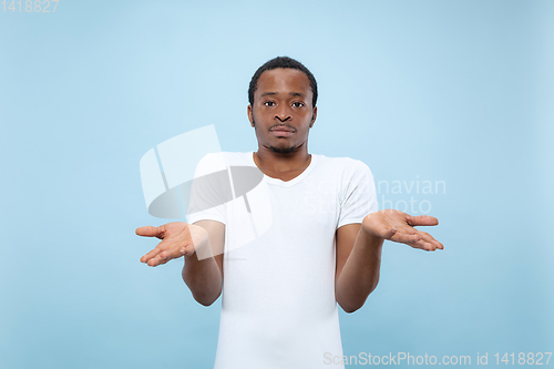 Image of Half-length close up portrait of young man on blue background.