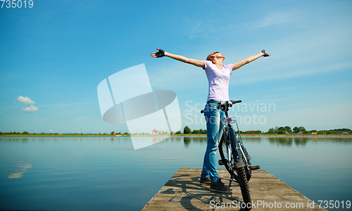 Image of Young woman raised her hands up in joy