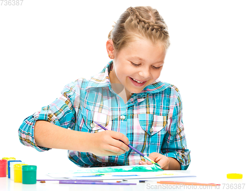 Image of Little girl is drawing using pencils