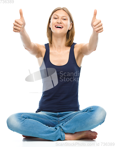 Image of Young happy woman is showing thumb up sign