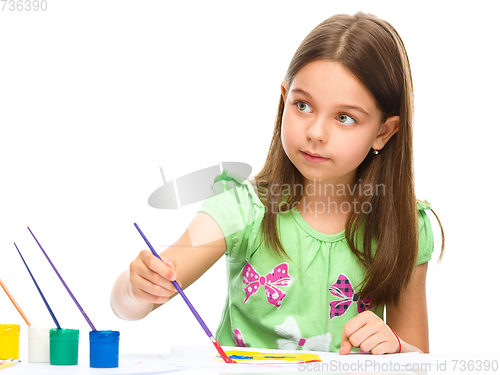 Image of Little girl is painting with gouache