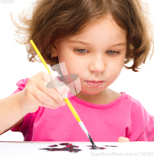 Image of Little girl is painting with gouache