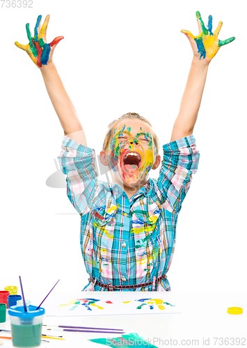 Image of Little girl is rising her hands up in joy