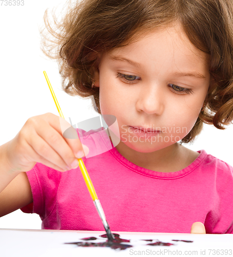 Image of Little girl is painting with gouache