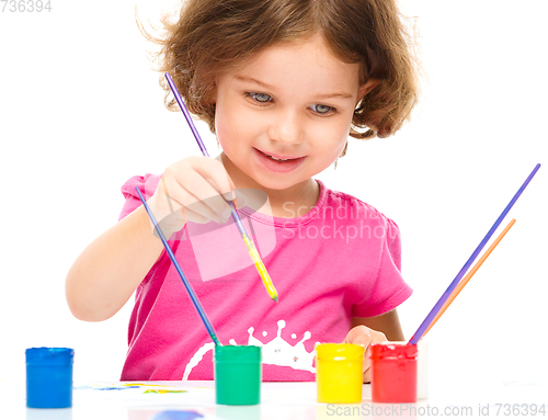 Image of Little girl is painting with gouache