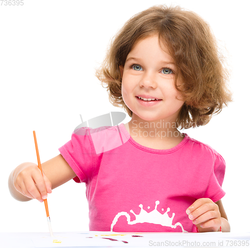 Image of Little girl is painting with gouache