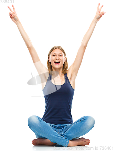 Image of Young woman is raised her hands up in joy