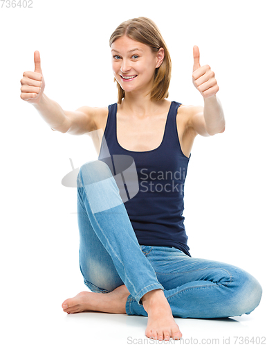 Image of Young happy woman is showing thumb up sign