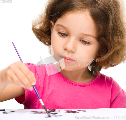 Image of Little girl is painting with gouache