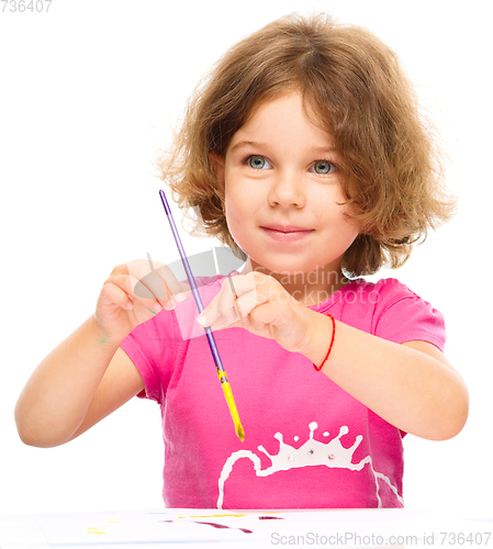 Image of Little girl is painting with gouache