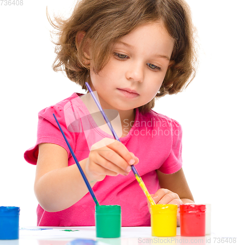 Image of Little girl is painting with gouache