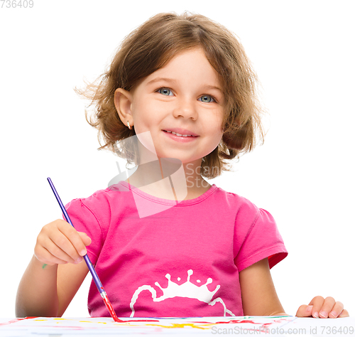 Image of Little girl is painting with gouache