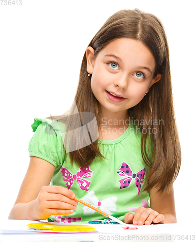 Image of Little girl is painting with gouache