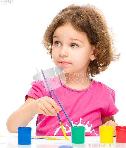 Image of Little girl is painting with gouache