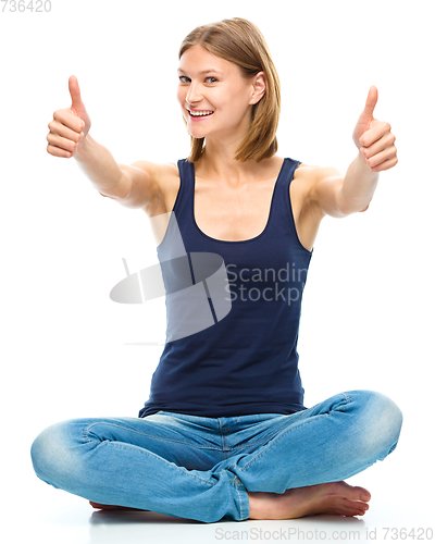 Image of Young happy woman is showing thumb up sign