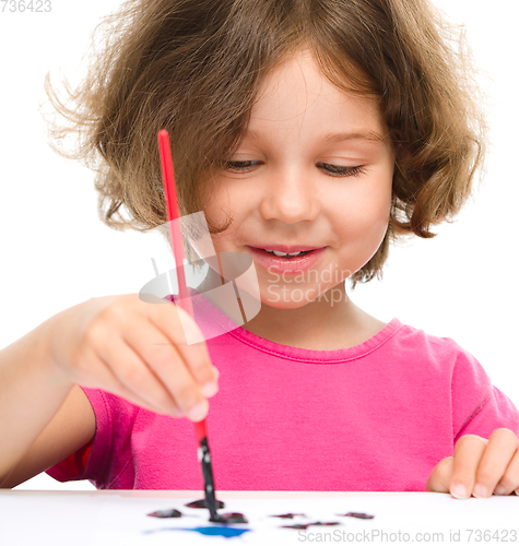 Image of Little girl is painting with gouache