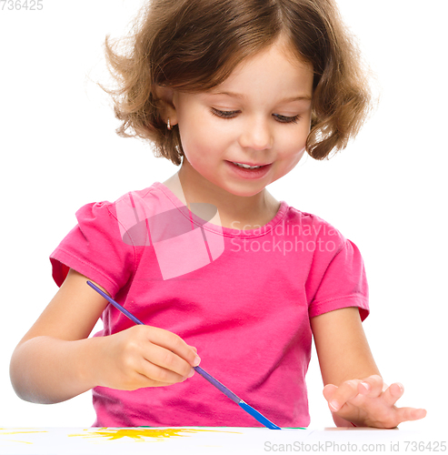 Image of Little girl is painting with gouache