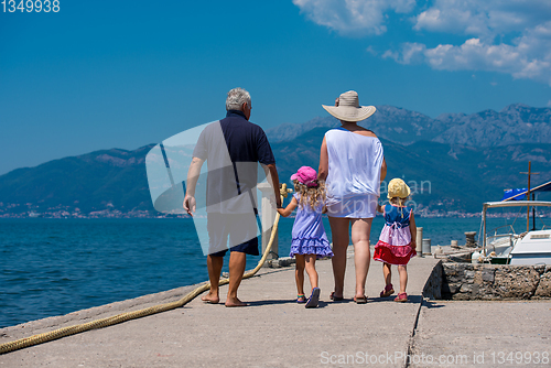 Image of grandparents and granddaughters walking by the sea