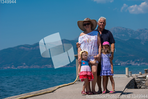 Image of portrait of grandparents and granddaughters standing by the sea