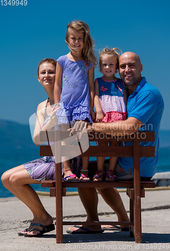 Image of portrait of young happy family with daughters by the sea