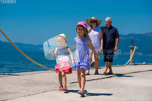 Image of grandparents and granddaughters walking by the sea