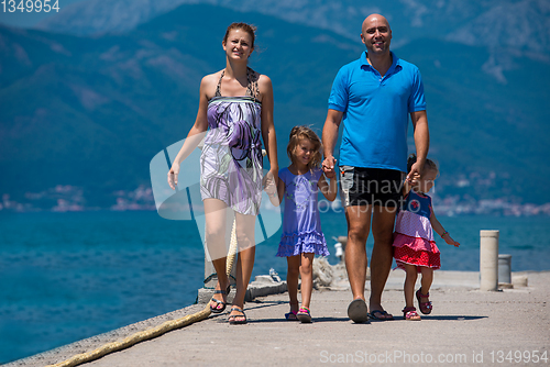 Image of young happy family walking by the sea