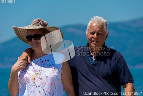 Image of senior couple hugging while walking  by the sea