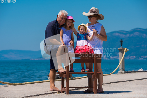 Image of portrait of grandparents and granddaughters by the sea