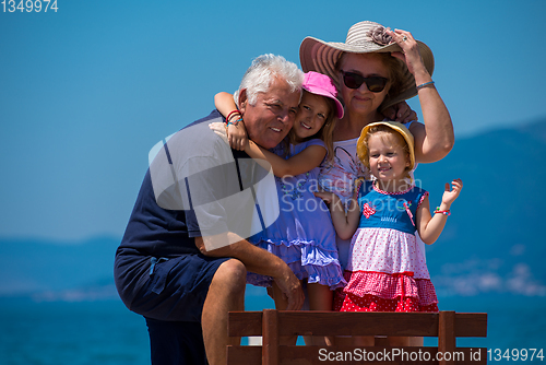 Image of portrait of grandparents and granddaughters by the sea