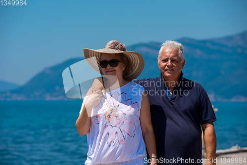 Image of senior couple hugging while walking  by the sea