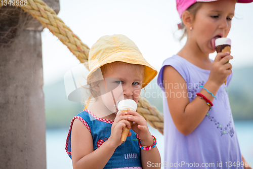 Image of little girls eating ice cream by the sea