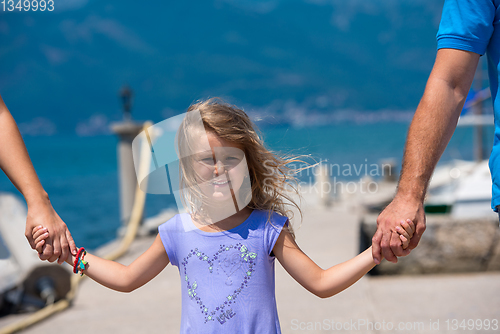 Image of young happy family walking by the sea