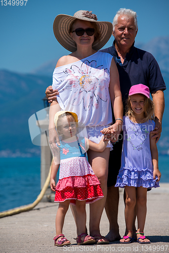 Image of portrait of grandparents and granddaughters standing by the sea