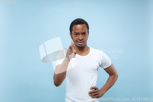 Image of Half-length close up portrait of young man on blue background.