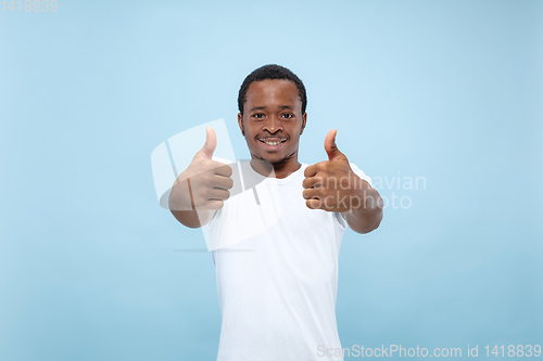 Image of Half-length close up portrait of young man on blue background.