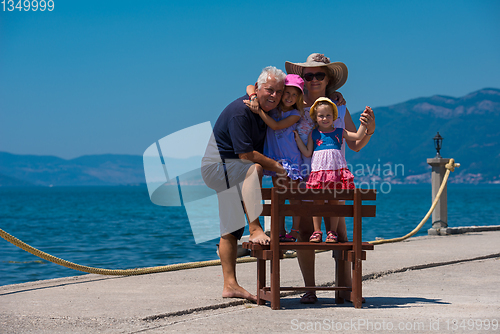 Image of portrait of grandparents and granddaughters by the sea