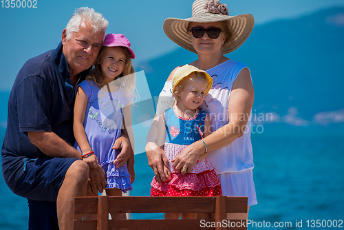 Image of portrait of grandparents and granddaughters by the sea