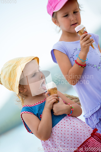 Image of little girls eating ice cream by the sea
