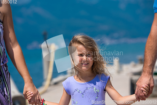 Image of young happy family walking by the sea