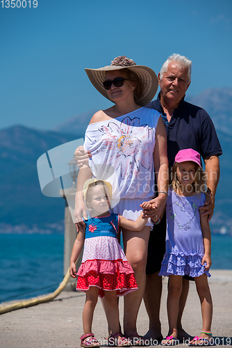 Image of portrait of grandparents and granddaughters standing by the sea
