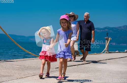 Image of grandparents and granddaughters walking by the sea