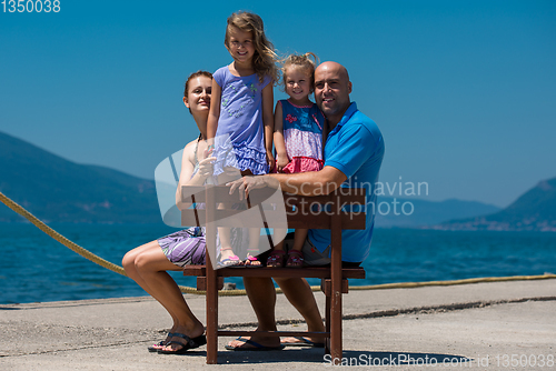 Image of portrait of young happy family with daughters by the sea
